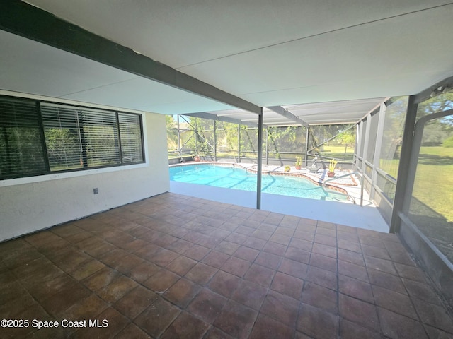 outdoor pool featuring glass enclosure and a patio