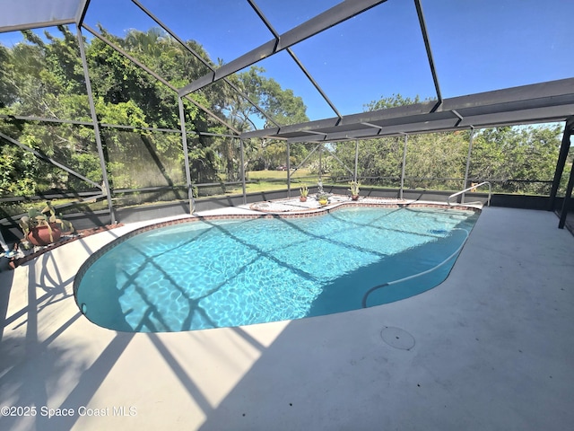 pool with glass enclosure and a patio