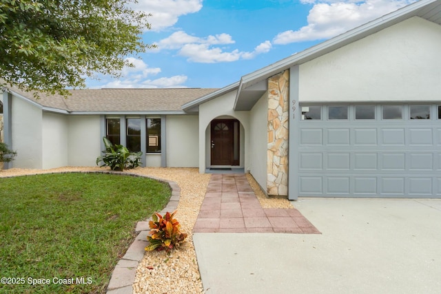 view of front of home featuring a garage, concrete driveway, a front lawn, stucco siding, and roof with shingles