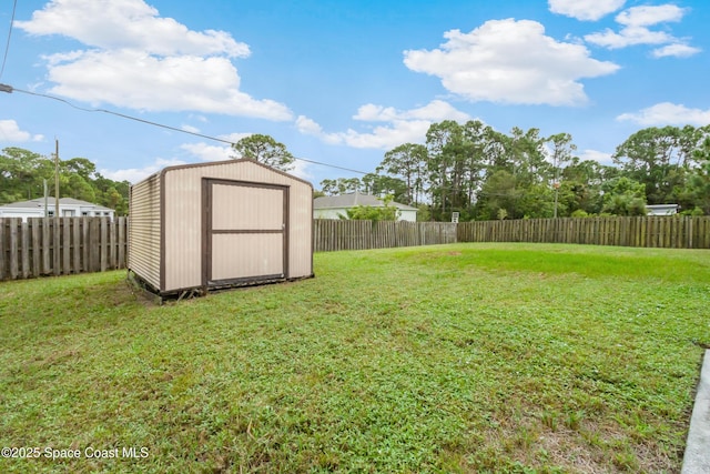 view of yard featuring a storage shed, an outbuilding, and a fenced backyard