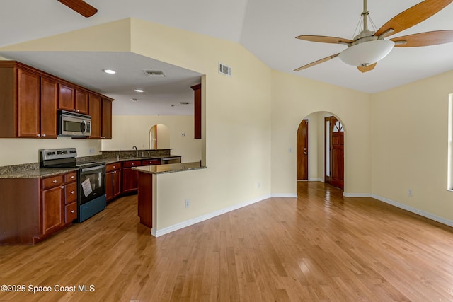 kitchen with visible vents, arched walkways, open floor plan, ceiling fan, and stainless steel appliances
