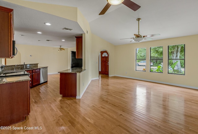 unfurnished living room featuring visible vents, arched walkways, a ceiling fan, light wood-style floors, and lofted ceiling