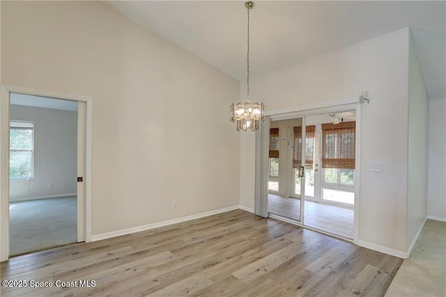 unfurnished dining area featuring french doors, wood finished floors, high vaulted ceiling, and baseboards