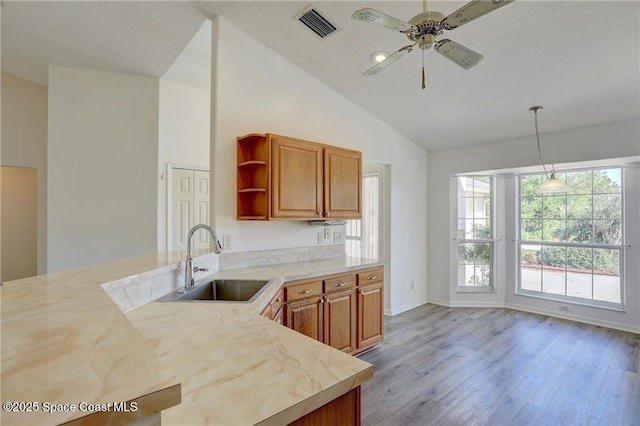kitchen with a ceiling fan, open shelves, visible vents, a sink, and lofted ceiling