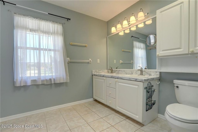 full bathroom with double vanity, baseboards, a sink, and toilet