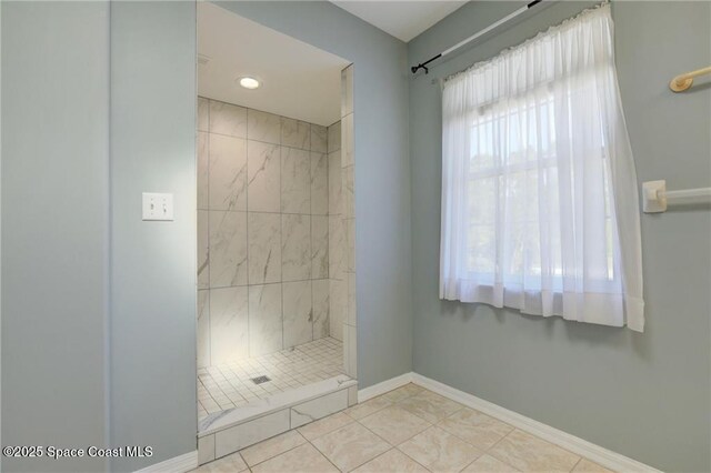 full bathroom featuring tile patterned flooring, baseboards, and a stall shower