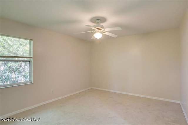 empty room featuring light carpet, ceiling fan, and baseboards