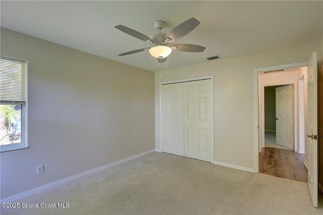 unfurnished bedroom with a closet, baseboards, carpet, and visible vents