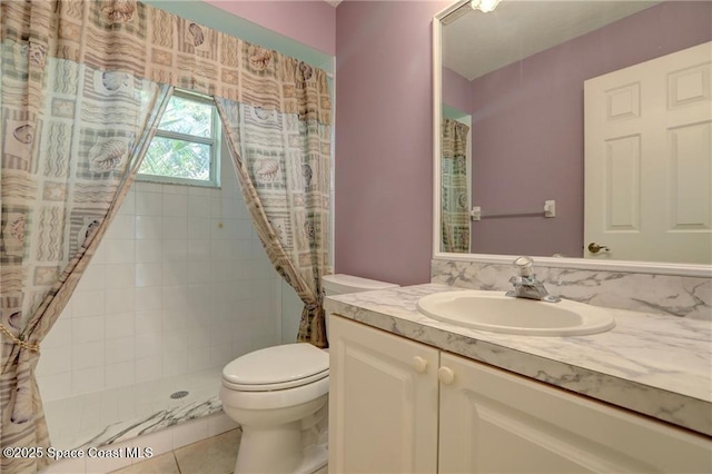 full bath featuring a tile shower, toilet, tile patterned flooring, and vanity