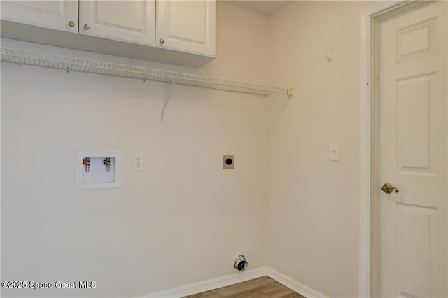 laundry area featuring hookup for an electric dryer, baseboards, hookup for a washing machine, cabinet space, and wood finished floors