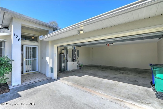 garage featuring driveway and water heater
