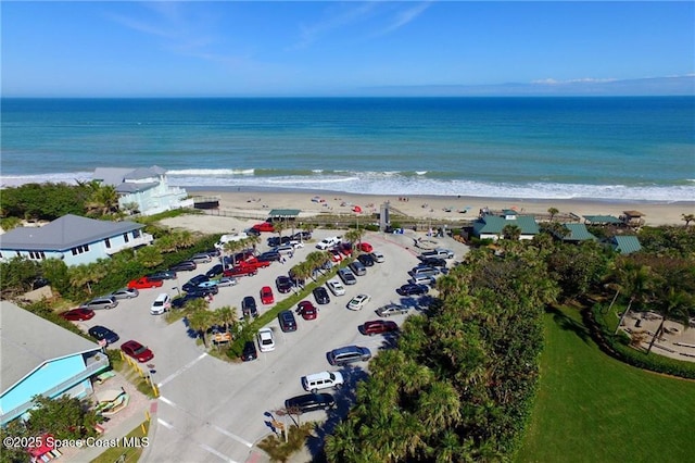drone / aerial view with a beach view and a water view
