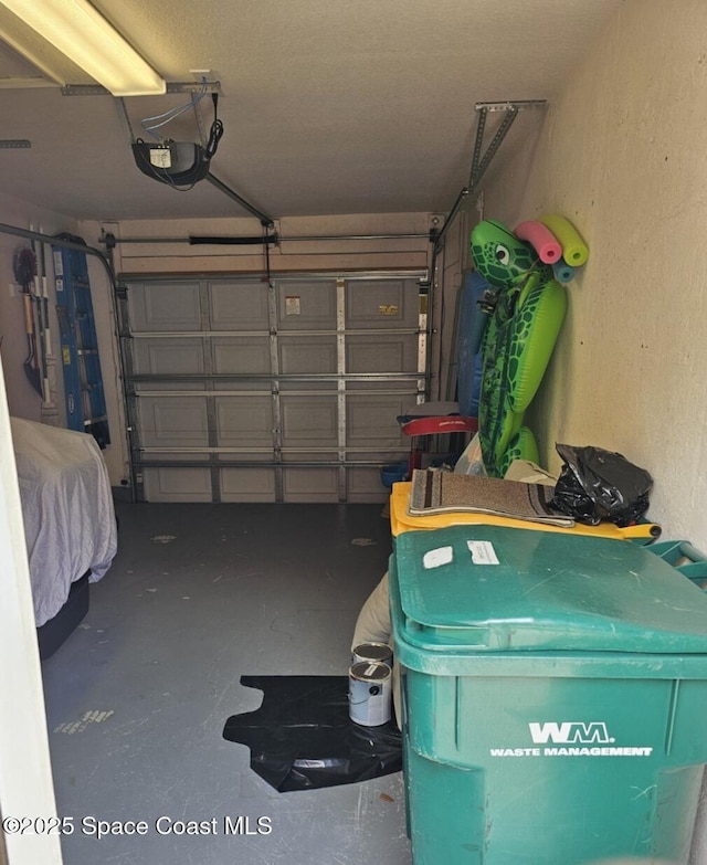garage with a textured wall and a garage door opener