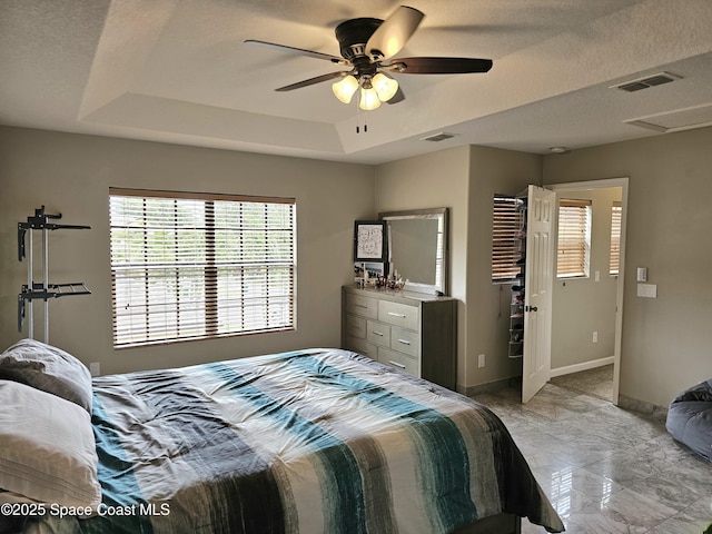 bedroom with a raised ceiling, baseboards, a ceiling fan, and visible vents