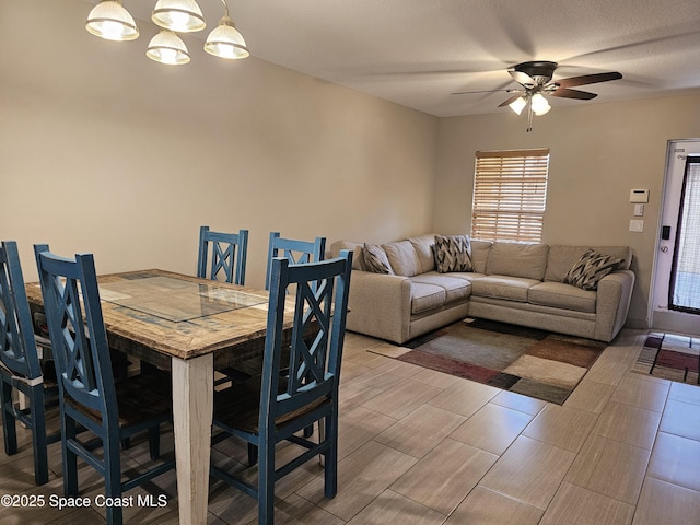 dining room featuring ceiling fan with notable chandelier