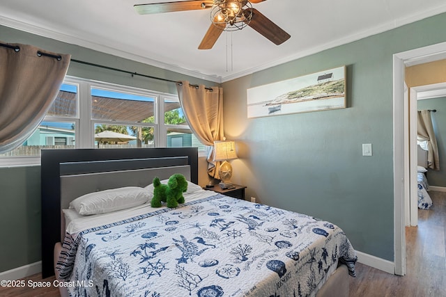 bedroom with a ceiling fan, wood finished floors, baseboards, and ornamental molding