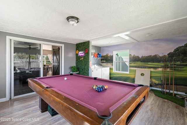 rec room with pool table, light wood-type flooring, washing machine and dryer, and a textured ceiling