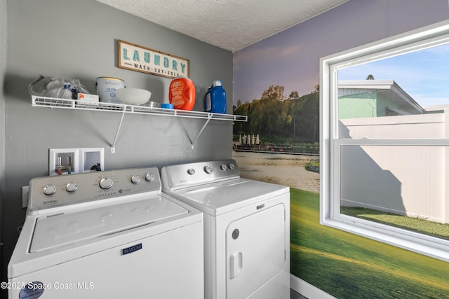 laundry area with separate washer and dryer, laundry area, and a textured ceiling