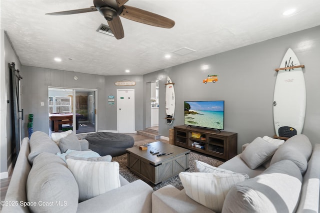 living room with wood finished floors, a ceiling fan, visible vents, and recessed lighting