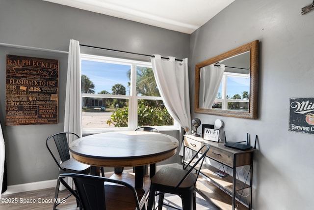 dining space featuring baseboards and wood finished floors