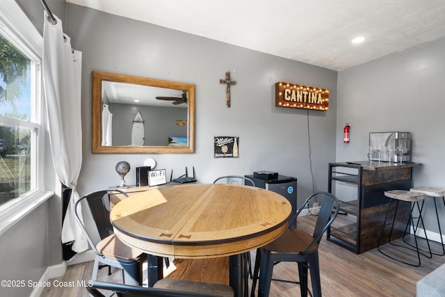 dining space with baseboards, recessed lighting, wood finished floors, and a healthy amount of sunlight