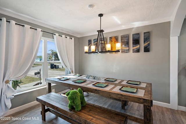 dining area with baseboards, a notable chandelier, wood finished floors, and a textured ceiling