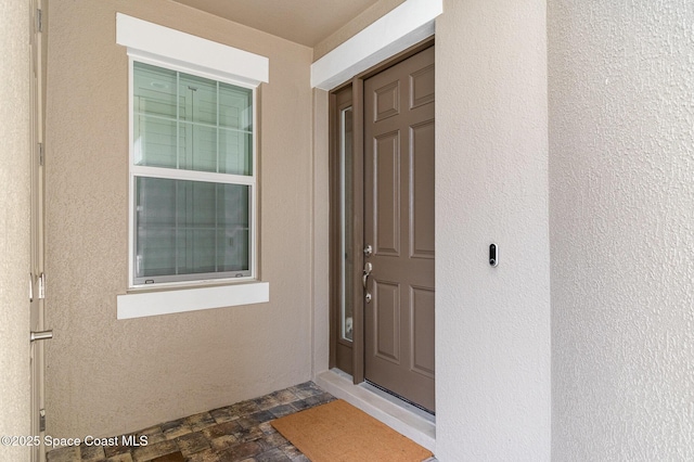 view of exterior entry featuring stucco siding