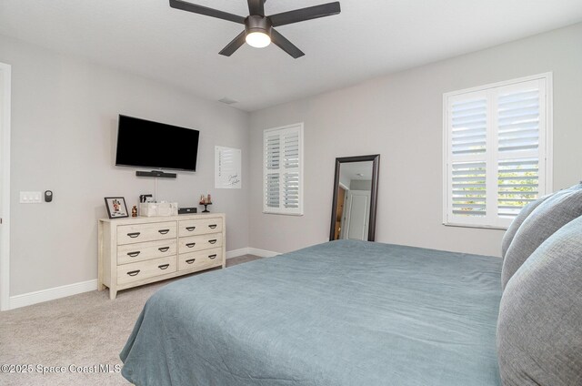 bedroom featuring baseboards, ceiling fan, and light colored carpet
