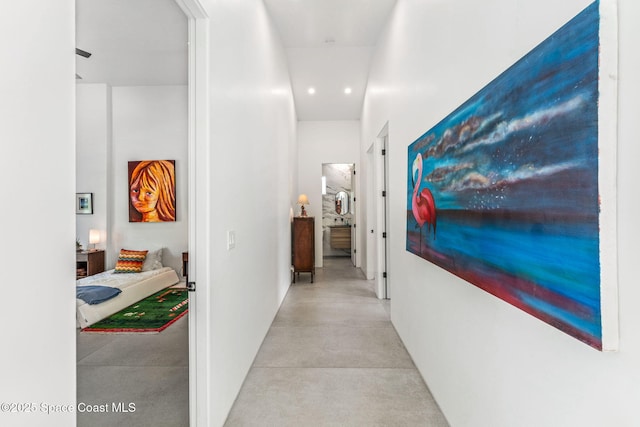 corridor featuring concrete flooring and recessed lighting