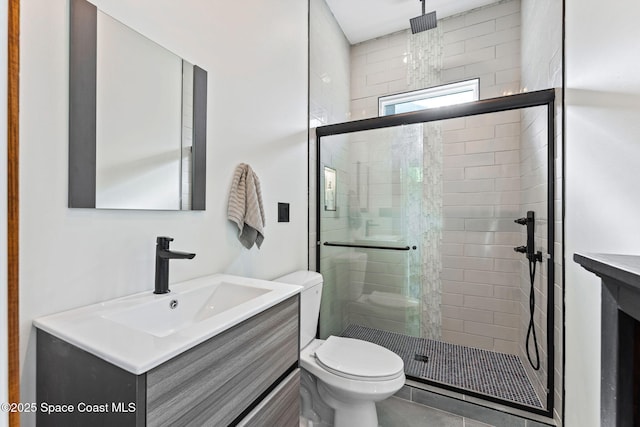 full bathroom featuring toilet, a shower stall, and vanity