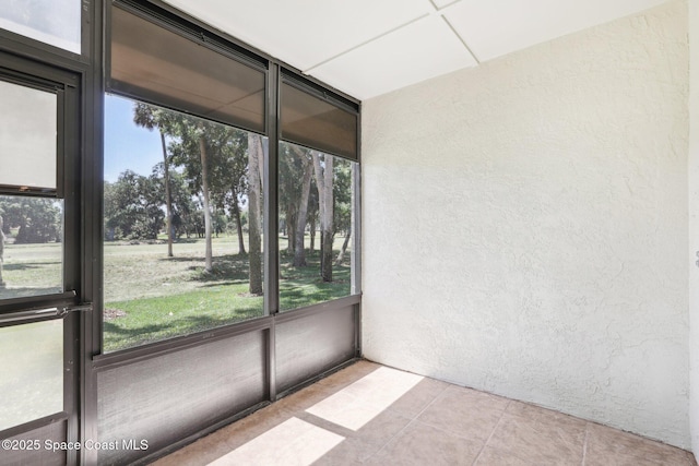 unfurnished sunroom featuring a textured wall and tile patterned flooring