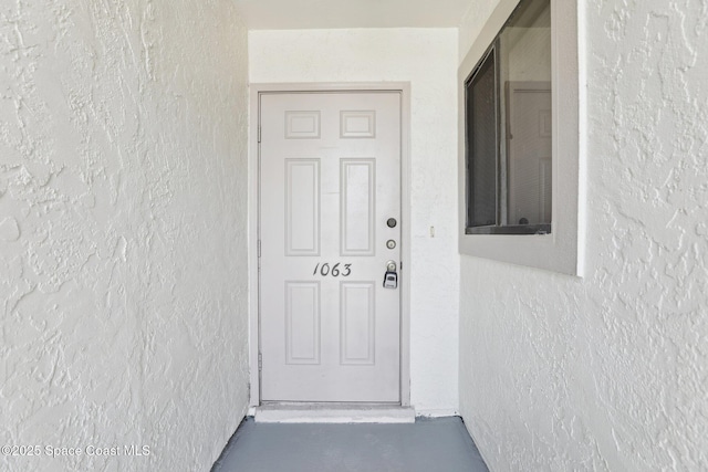 view of exterior entry featuring stucco siding