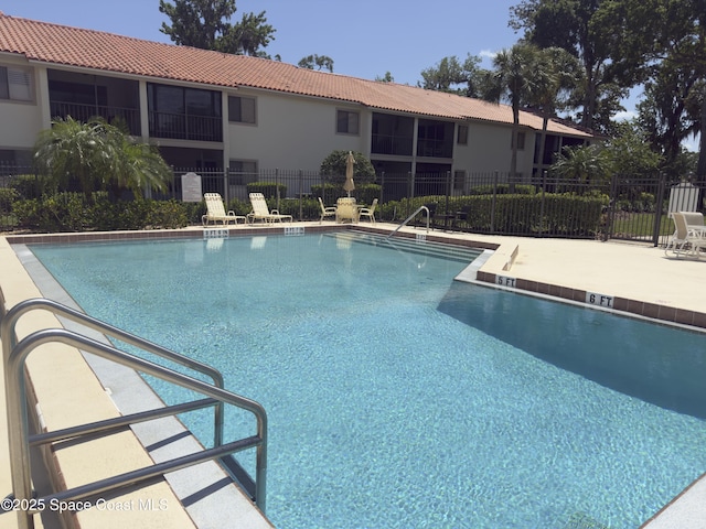 pool featuring a patio and fence