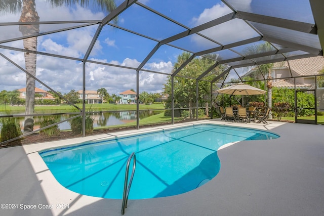 outdoor pool featuring a lanai, a patio area, and a water view