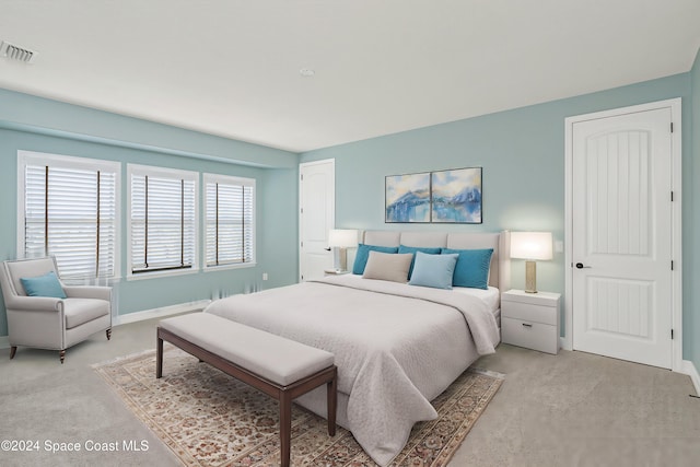 bedroom with visible vents, baseboards, and light carpet