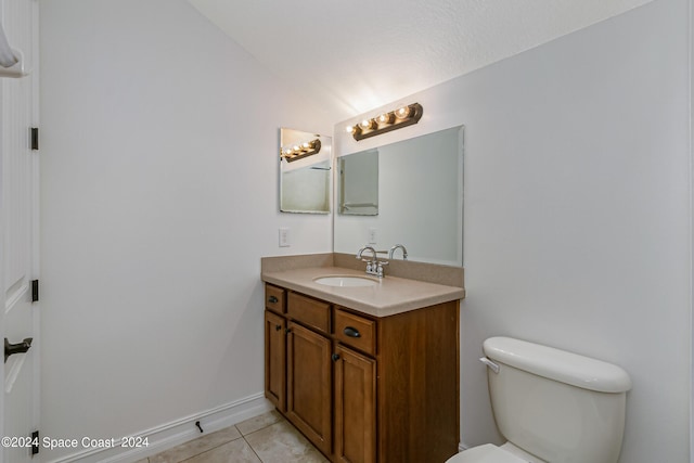 bathroom with toilet, tile patterned floors, and vanity