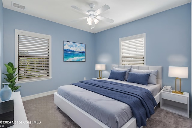 carpeted bedroom featuring baseboards, a ceiling fan, and visible vents
