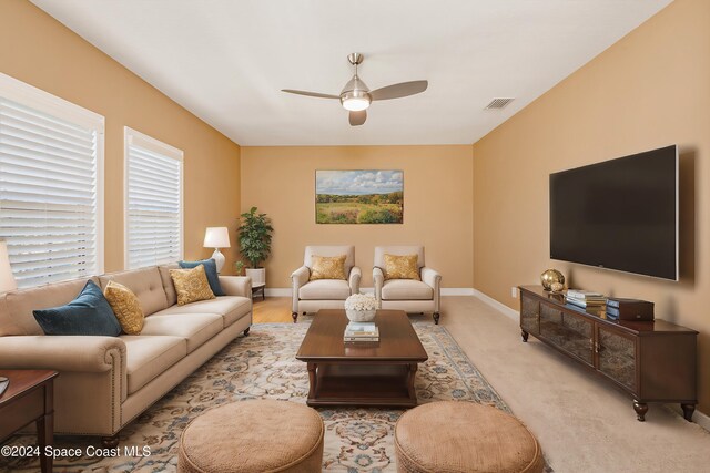 living room featuring ceiling fan, baseboards, and visible vents