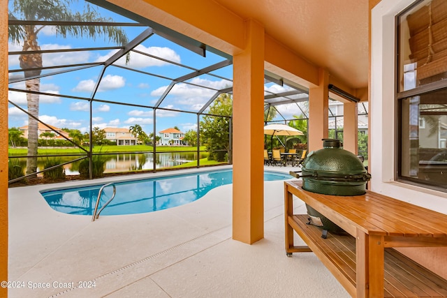 pool featuring a water view, a patio area, and glass enclosure
