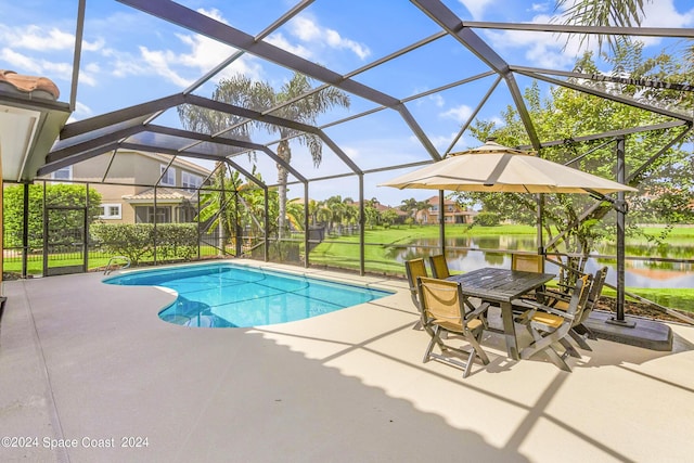 outdoor pool featuring a patio, glass enclosure, and a water view