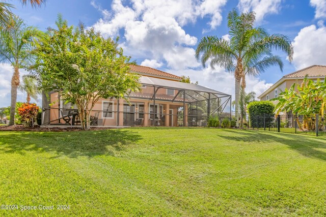 view of yard featuring a lanai and fence