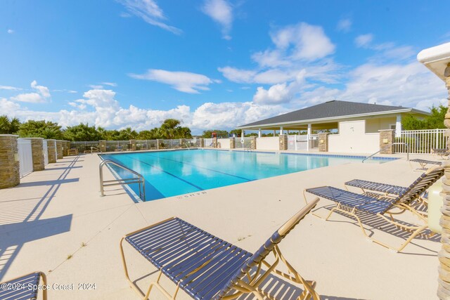 community pool featuring a patio and fence