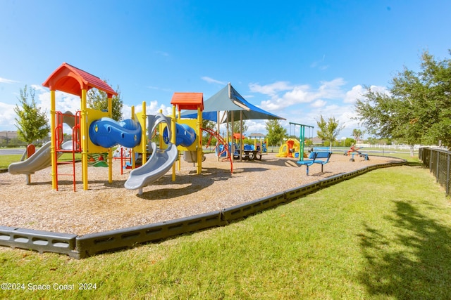 community play area featuring fence and a lawn