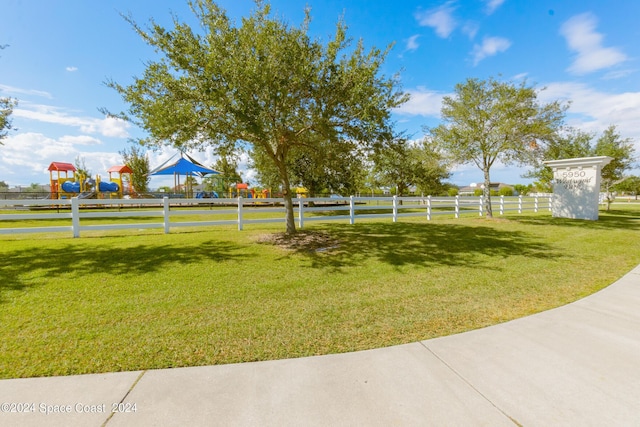 view of yard featuring playground community and fence