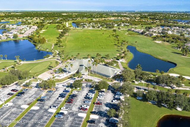 drone / aerial view with golf course view, a residential view, and a water view