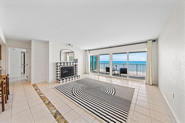2101 Atlantic St Unit 531, Melbourne Beach, FL 32951 - living area with a water view, a tiled fireplace, tile patterned flooring, and a textured wall