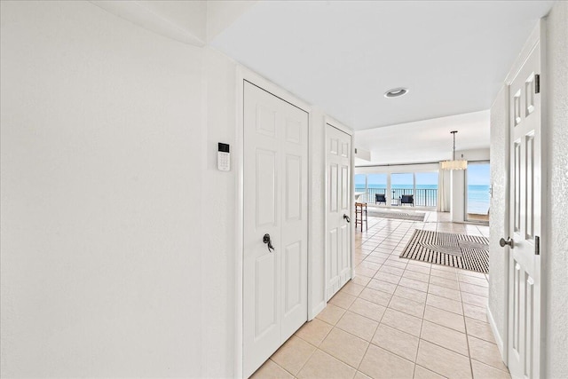 2101 Atlantic St Unit 531, Melbourne Beach, FL 32951 - hall with a water view, light tile patterned floors, a chandelier, and floor to ceiling windows