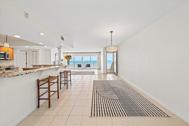 2101 Atlantic St Unit 531, Melbourne Beach, FL 32951 - kitchen featuring a breakfast bar, light stone counters, recessed lighting, visible vents, and appliances with stainless steel finishes