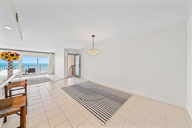 2101 Atlantic St Unit 531, Melbourne Beach, FL 32951 - unfurnished room with a chandelier, baseboards, light tile patterned flooring, and a water view