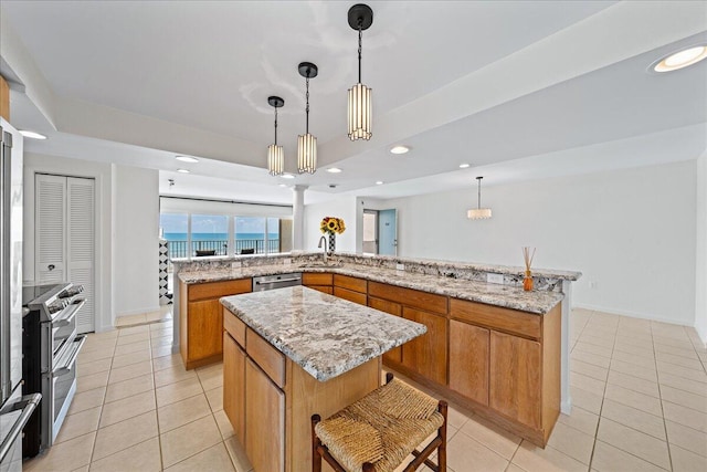 2101 Atlantic St Unit 531, Melbourne Beach, FL 32951 - kitchen featuring a tray ceiling, appliances with stainless steel finishes, a sink, brown cabinets, and a spacious island